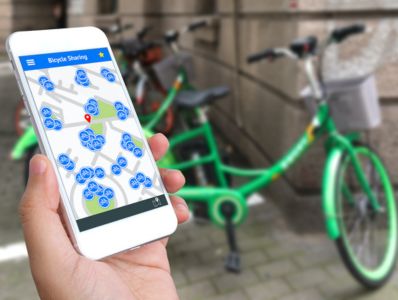 A person rents a green bicycle using a phone app.