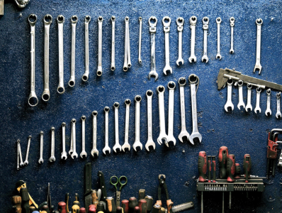 Wrenches and other repair tools mounted on a wall.