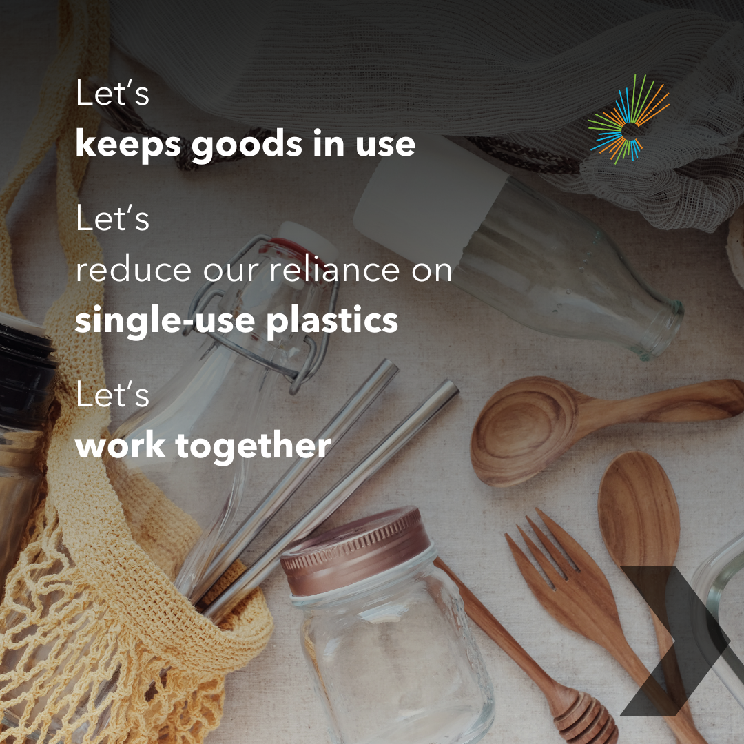 A neatly organized spread of reusable items, including jars, metal straws, wooden utensils, and a market bag. Circular Economy Month starburst motif. A black chevron indicates to swipe to the next slide. Motivational text reads, "let's keep goods in use. Let's reduce our reliance on single-use plastics. Let's work together."