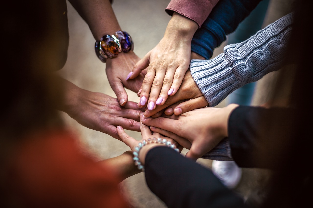 Une équipe avec les mains empilées au centre de l'image. Photo : Bob Dymt.